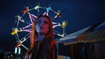 Rumble Through the Dark Movie: Annette (Bella Thorne), with lots of colorful makeup on and standing in front of a Ferris Wheel, has a pensive look on her face