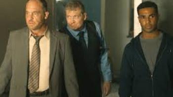 Safe House Movie: 2 White men in suits and 1 Black man in hoodie walk