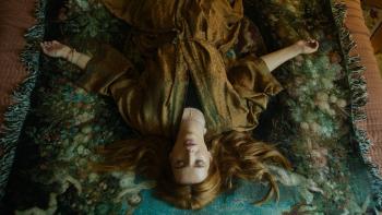 Saint Clare Movie: Viewed upside down, Clare lies on her bed, eyes closed as if concentrating deeply