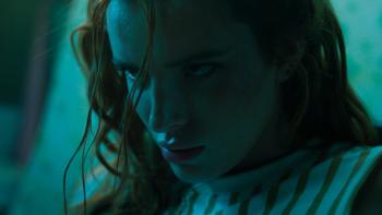 Saint Clare Movie: Clare glares at something with barely controlled rage, a single strand of hair dangling across her face