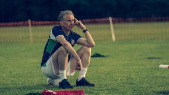 Saipan: Mick McCarthy sitting down on a soccer ball on a soccer pitch thinking