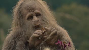 Sasquatch Sunset Movie: A Sasquatch (Jesse Eisenberg) contemplates a butterfly that sits on his finger