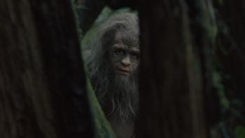 Sasquatch Sunset Movie: A Sasquatch (Riley Keough) peers between two trees