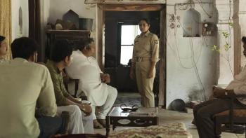 Santosh: An Indian female police officer stands talking to a room of five men