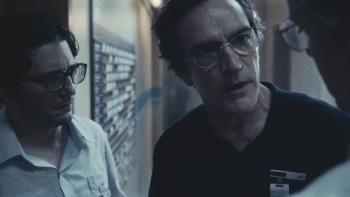 September 5 Movie: Geoff, Bader, and Roone (in profile) have a tense, hushed conversation in the hallway