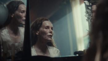 She Will: Alice Krige's head and shoulders are reflected in a mirror in front of a window.