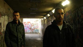 Shifty: A young White male and a young Asian male in an underpass