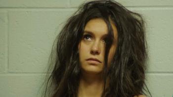 Sick Girl Movie: Wren leans against the cinderblock wall of a jail