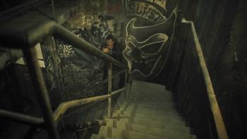 Silent Night Movie: Seen from above as he climbs a graffiti-covered staircase, Brian Godlock (Joel Kinnaman) keeps his gun raised, on guard and ready for anything