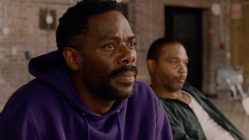 Sing Sing Movie: Seated, Divine G (Colman Domingo) leans forward, listening carefully, while Divine Eye slouches behind him