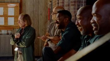 Sing Sing Movie: Brent, Mike Mike, Divine G, and other smiling men gather and look to the left, hoping for good news