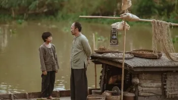 Song of the South: Huynh Hao Khang talks with a man by a boat.