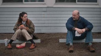 Sorry, Baby: Agnes (Eva Victor) eats a sandwich while talking to Pete (John Carroll Lynch); both sit on a parking curb