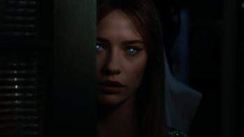 Soulm8te movie: Sara, with sinister, glowing eyes, peeks out from behind a doorway