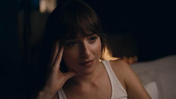 Splitsville Movie: Julie (Dakota Johnson) rests her head in one hand while looking thoughtful