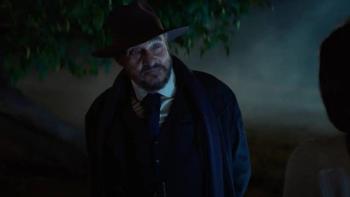 Starbright movie: John Rhys-Davies stands in the dark wearing a suit and hat