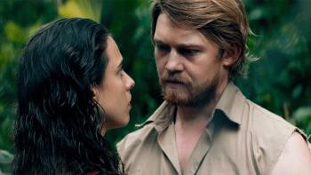 Stars at Noon: Margaret Qualley and Joe Alwyn lok at each other seriously against a backdrop of trees.