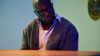 Stepfather Movie: Taye Diggs with glasses and sweater, seated in dimly lit room.