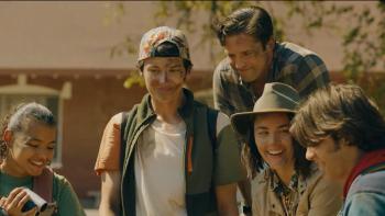 Three teens stand with two adults, all are smiling and their faces are covered with dirt implying they've just finished an adventure