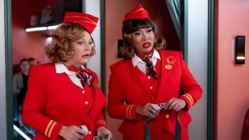 Stop! That! Train! movie: Two attendants in red uniforms stand in a train aisle