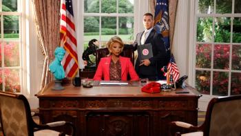 Stop! That! Train! movie: RuPaul, playing the president, sits at a desk in a facsimile of the Oval Office