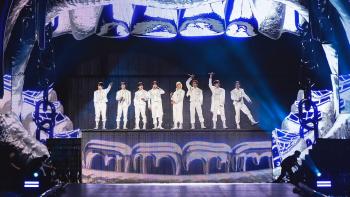 Stray Kids: The dominATE Experience movie: The Stray Kids sing on stage inside an open mouth projection