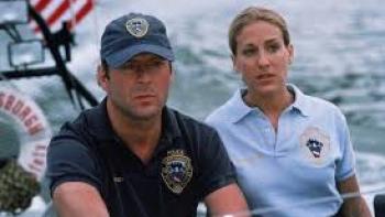 Striking Distance: Two people in police uniforms on a boat, looking serious.