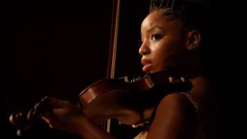 Strung: Chloe Bailey playing violin under soft lighting.