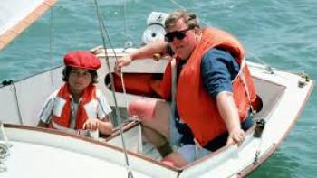 Summer Rental Movie: Man in life preserver on boat with kid