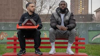 Sumotherhood: Adam Deacon and Jazzie Zonzolo sit on a bench holding a pizza box