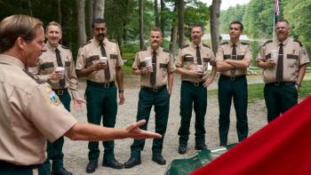 Super Troopers 3 Movie: Troopers, holding coffees, chat outdoors in a wooded area