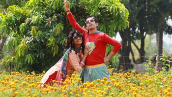 Superboys of Malegaon: An Indian woman and man who is dressed as a superhero in a field