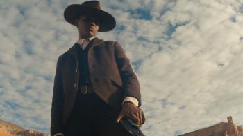 Surrounded Movie: Mo Washington (Letitia Wright) stands against a cloudy sky, looking down on something, a gun in her hand