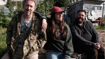 Swede Caroline: Richard Lumsden, Jo Hartley, and Celyn Jones sit together on a garden wall