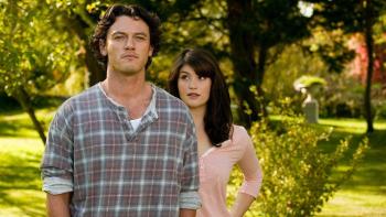 Tamara Drewe: Luke Evans stands in a field with Gemma Arterton looking at him and smiling from over his shoulder