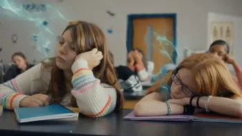 The Magician's Raincoat: Two kids lay on their school desk with sleepy expressions