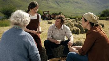 That They May Face the Rising Sun: A White man and woman gather together with an older woman and young girl to take a break while working a field