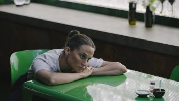 The Assessment movie: Alicia Vikander slumps over a green kitchen table, her head on her arm and food pushed in front of her