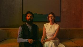 The Assessment movie: Himesh Patel and Elizabeth Olsen sit on a couch looking nervously hopeful