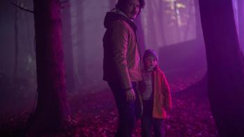 The Astronaut movie: Gabriel Luna and a child stand in an eerily lit forest