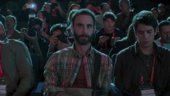 The Champion movie: Spanish bearded man in plaid shirt sits with other reporters and photographers at a press event