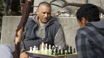 The Dark Horse Movie: An adult man plays chess with a young man