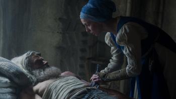 The Death of Robin Hood movie: Sister Brigid (Jodie Comer) leans over Robin Hood (Hugh Jackman) while bandaging his wounds