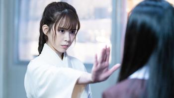 The Divine Protector - Master Salt Begins movie screenshot 1: Master Salt in traditional clothes raises a hand, flat palm, towards Nanako.