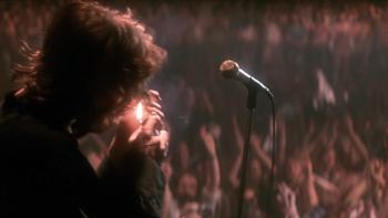 The Doors movie: Jim Morrison lights up a cigarette on stage in front of a huge crowd