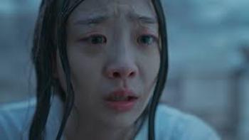 The Great Flood movie: Kim Da-mi with long black hair in white t-shirt has tears in her eyes, standing while outside in pouring rain, soaking wet