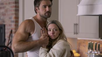 The Housemaid movie: Andrew (Brandon Sklenar) wears a white tank and holds wife Nina (Amanda Seyfried) close to him