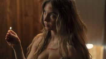 The Housemaid movie: Millie (Sydney Sweeney) holds a lit match while wearing a tank top, blood smeared on her face and chest