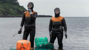 The Last of the Sea Women: Two divers by the ocean.