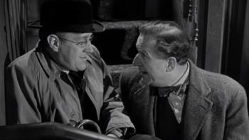 The Lavender Hill Mob: Two White men sit on stairs together wearing coats, hat, and one carries an umbrella